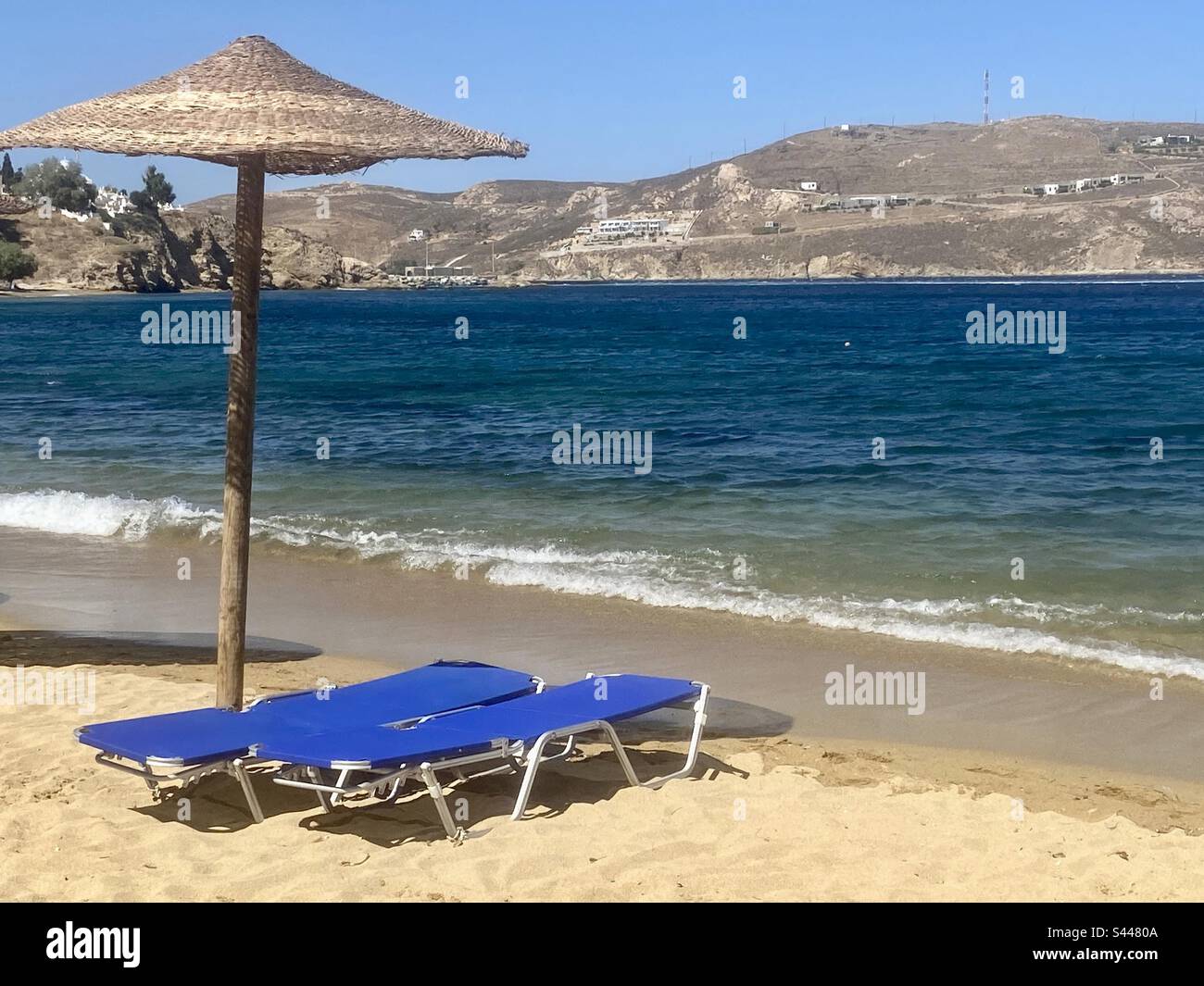 Blue beach loungers and umbrella, serifos, Greece - Smartphone Captured Stock Image