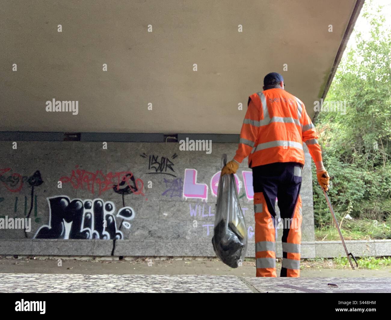 Serco street cleaner in hi vis uniform picking litter Stock Photo Alamy