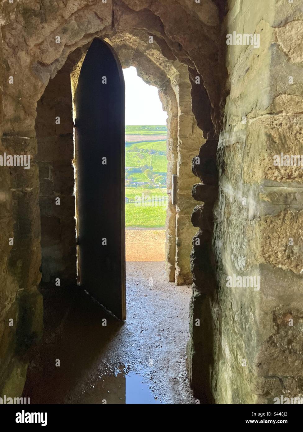 Ancient door way from St Catherine’s chapel opening to the bright summer fields of Abbotsbury, Dorset, England Stock Photo