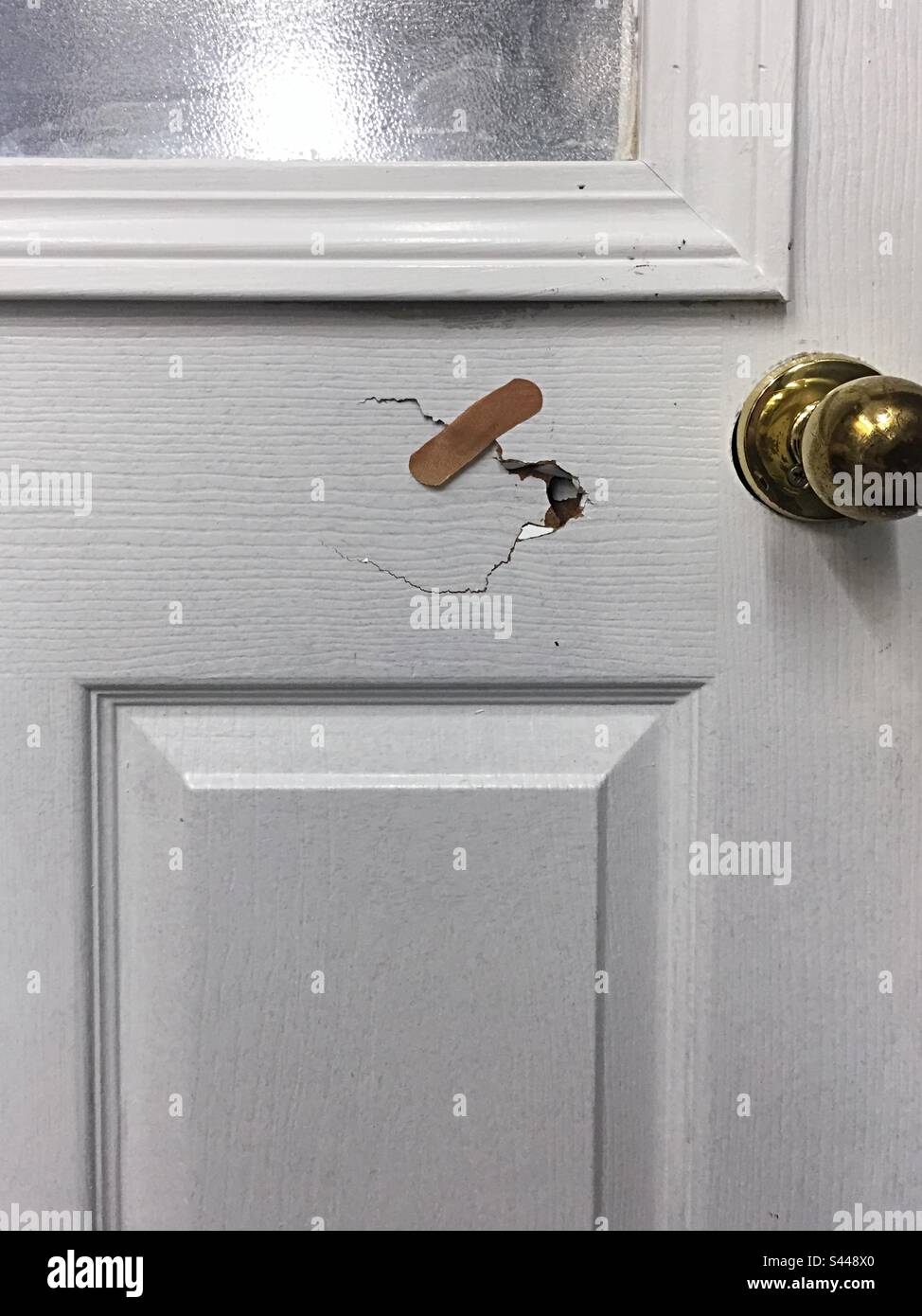 Cracked door patched with a band-aid - Smartphone Captured Stock Image