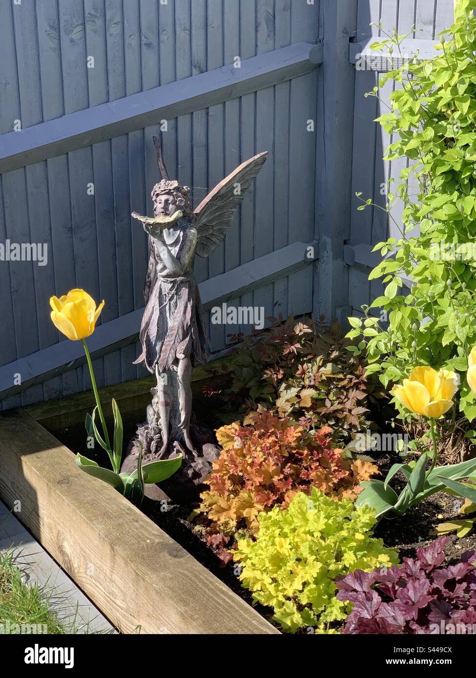 A flower bed with a fairy statue. Stock Photo