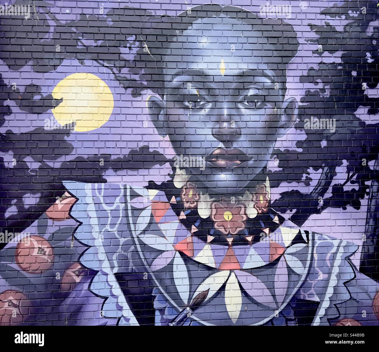 A section of a mural executed as part of the Worcester paint festival, repeating in black girl painted in a pallet of purples - Smartphone Captured Stock Image