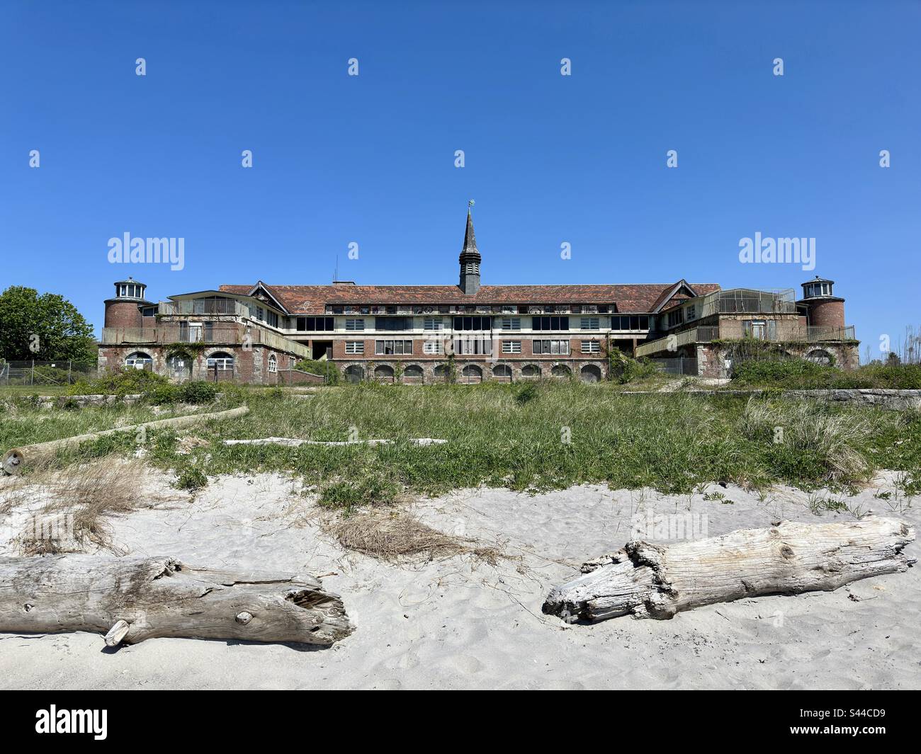 Waterford, Connecticut, USA:  Seaside State Park, formerly the Seaside Sanatorium.  Sandy beach with two logs in the foreground. Architect was Cass Gilbert. - Smartphone Captured Stock Image