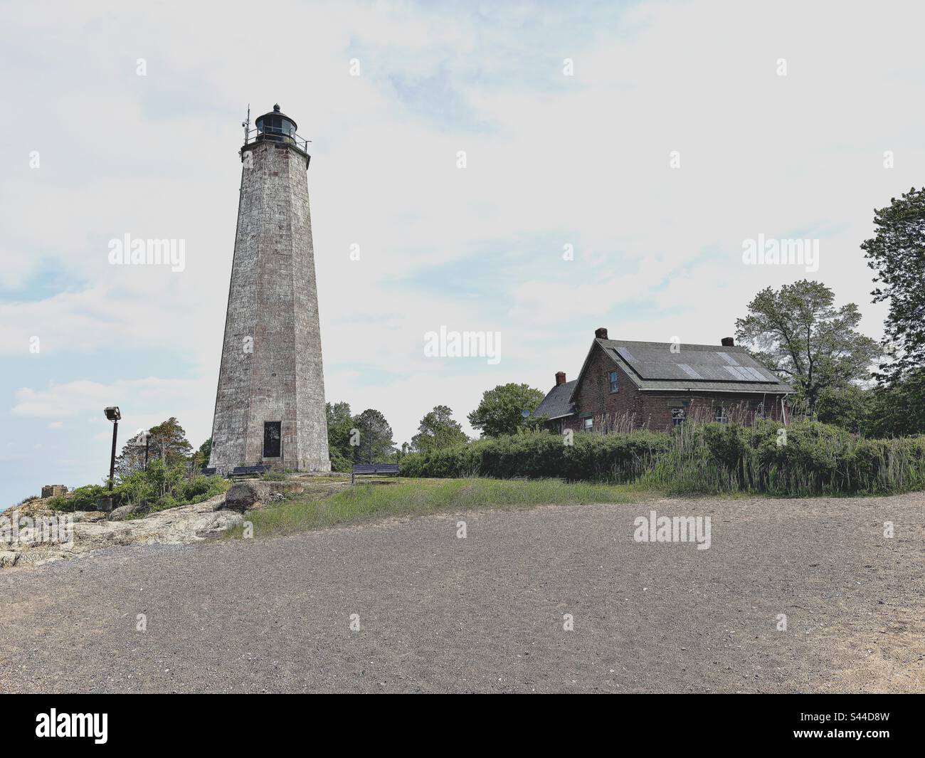 New Haven, Connecticut, USA: Lighthouse and red house at Lighthouse Point Park with small beach area. - Smartphone Captured Stock Image