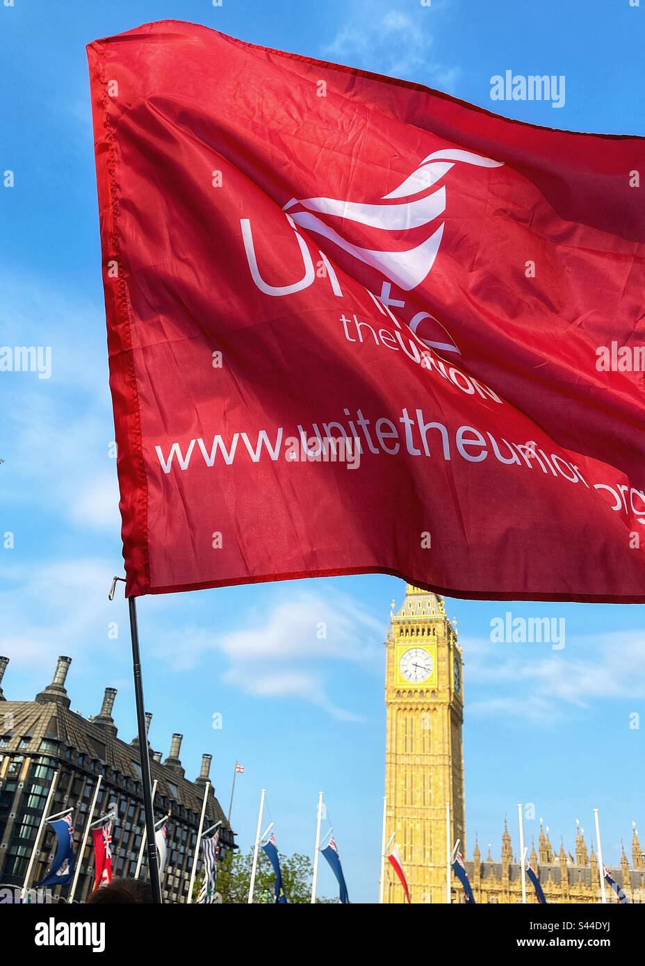 Unite the Union flag with Big Ben and Parliament in the background. Flag flying during right to strike protest in Parliament Square London SW1 - Smartphone Captured Stock Image