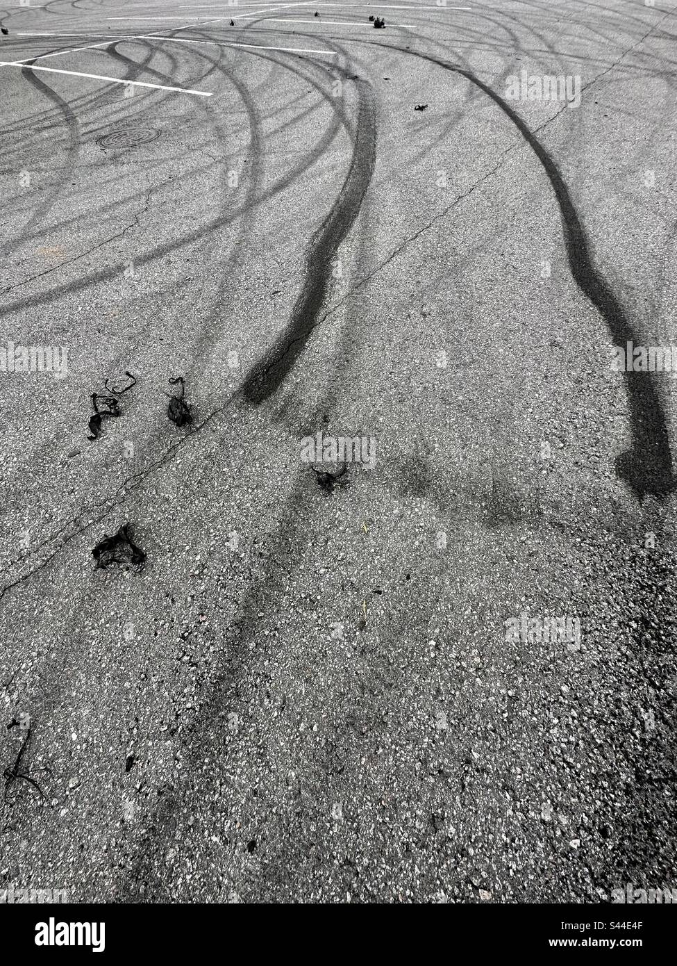 Car tire marks and pieces on a parking lot - Smartphone Captured Stock Image