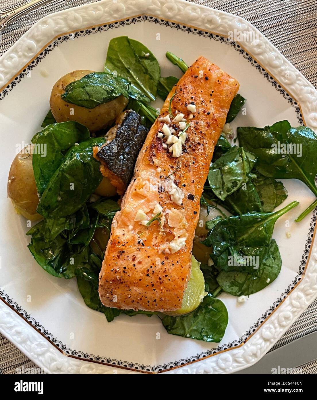 Flat lay oven oven roasted fillet of salmon on a bed of spinach with new potatoes, 2023, USA - Smartphone Captured Stock Image