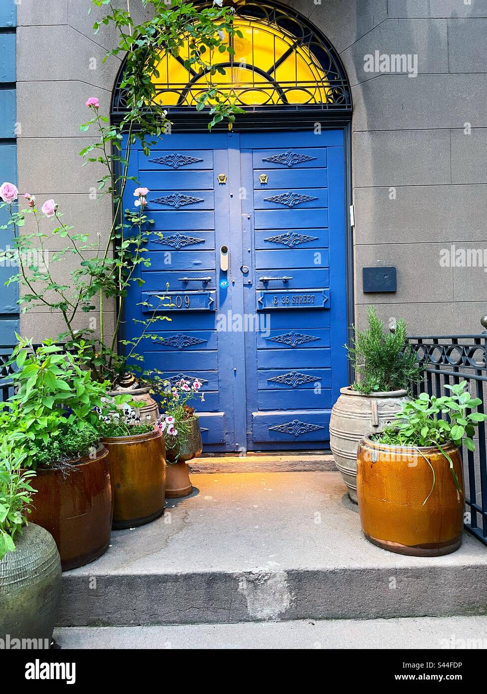 A colorful blue door at the entrance way of a historic brownstone on E. 35th St. in the Murray Hill historic district of Manhattan, New York City, USA, 2023 - Smartphone Captured Stock Image