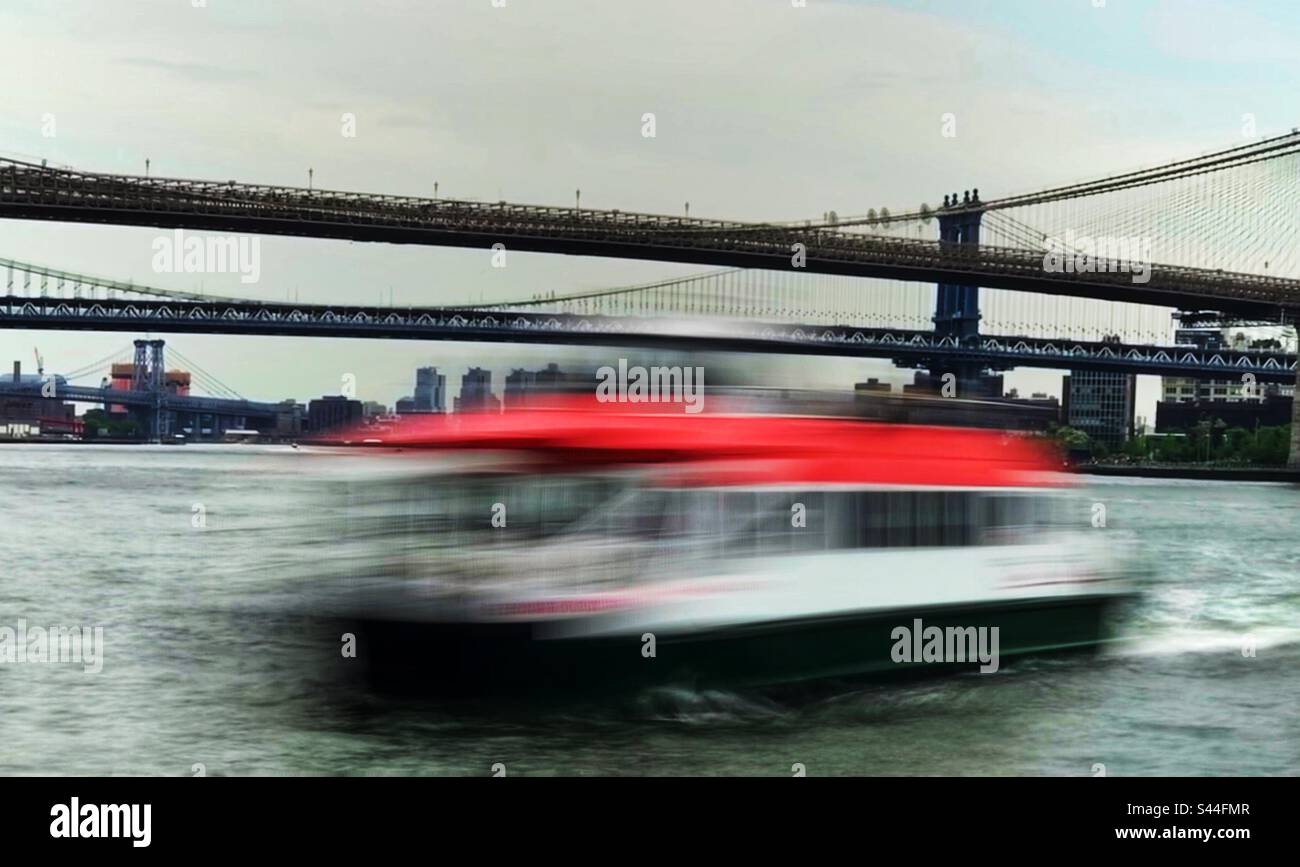 Red ferry sailing under the bridge. Stock Photo