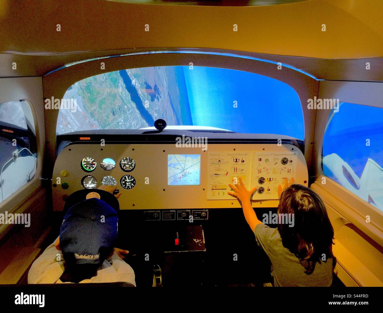 Two kids in a flight simulator. Discovering cockpit. Experiencing an