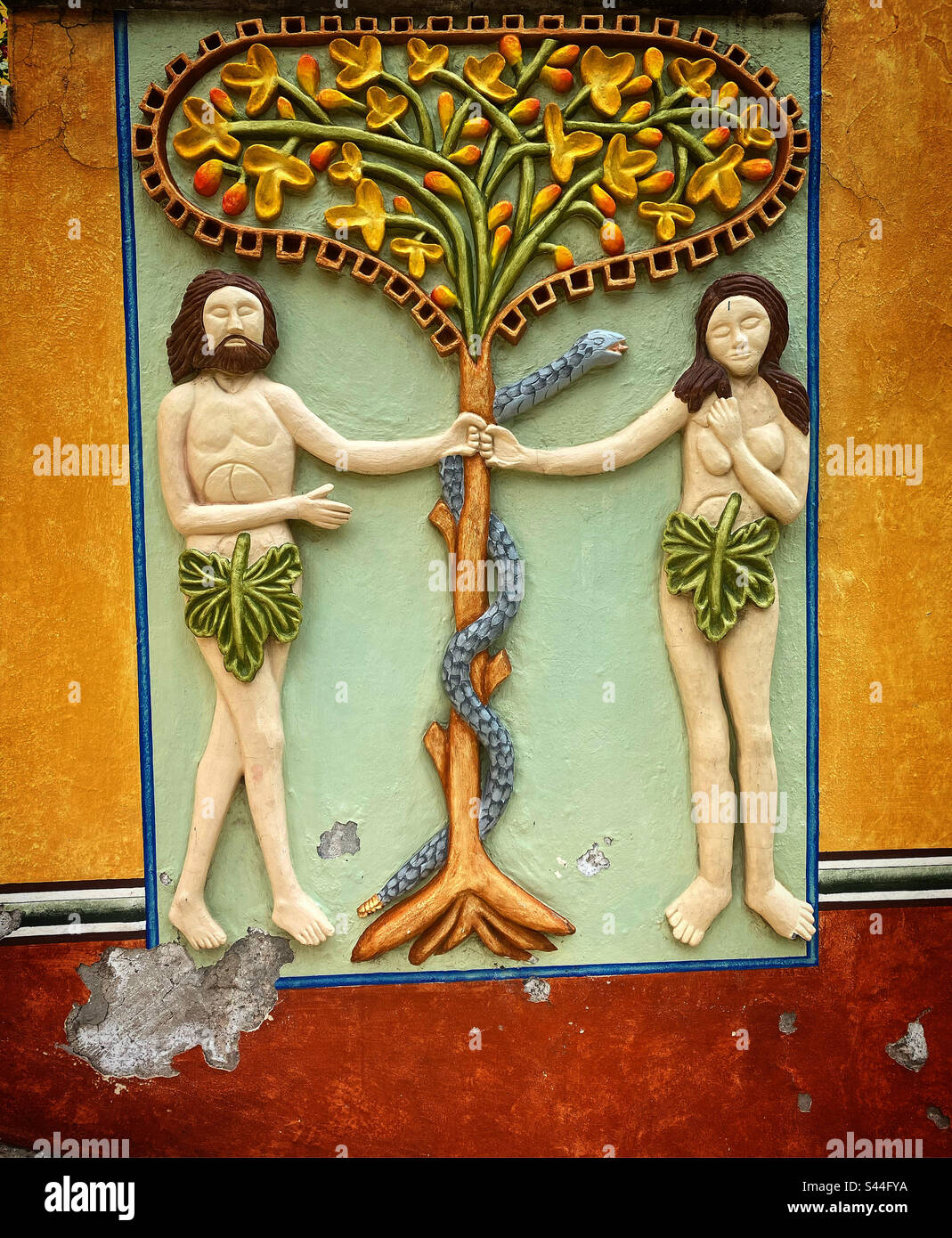 A relief of Adam and Eve and the old serpent in the tree of knowledge of the good and evil decorates a garden in the Basilica of Nuestra Señora de los Dolores de Soriano in Colon, Queretaro, Mexico Stock Photo