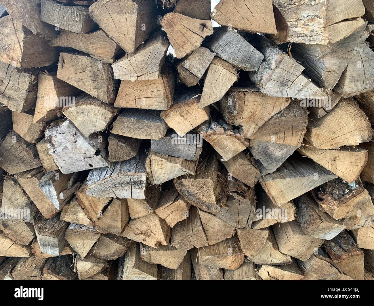 A rack of firewood made of split logs. Stock Photo