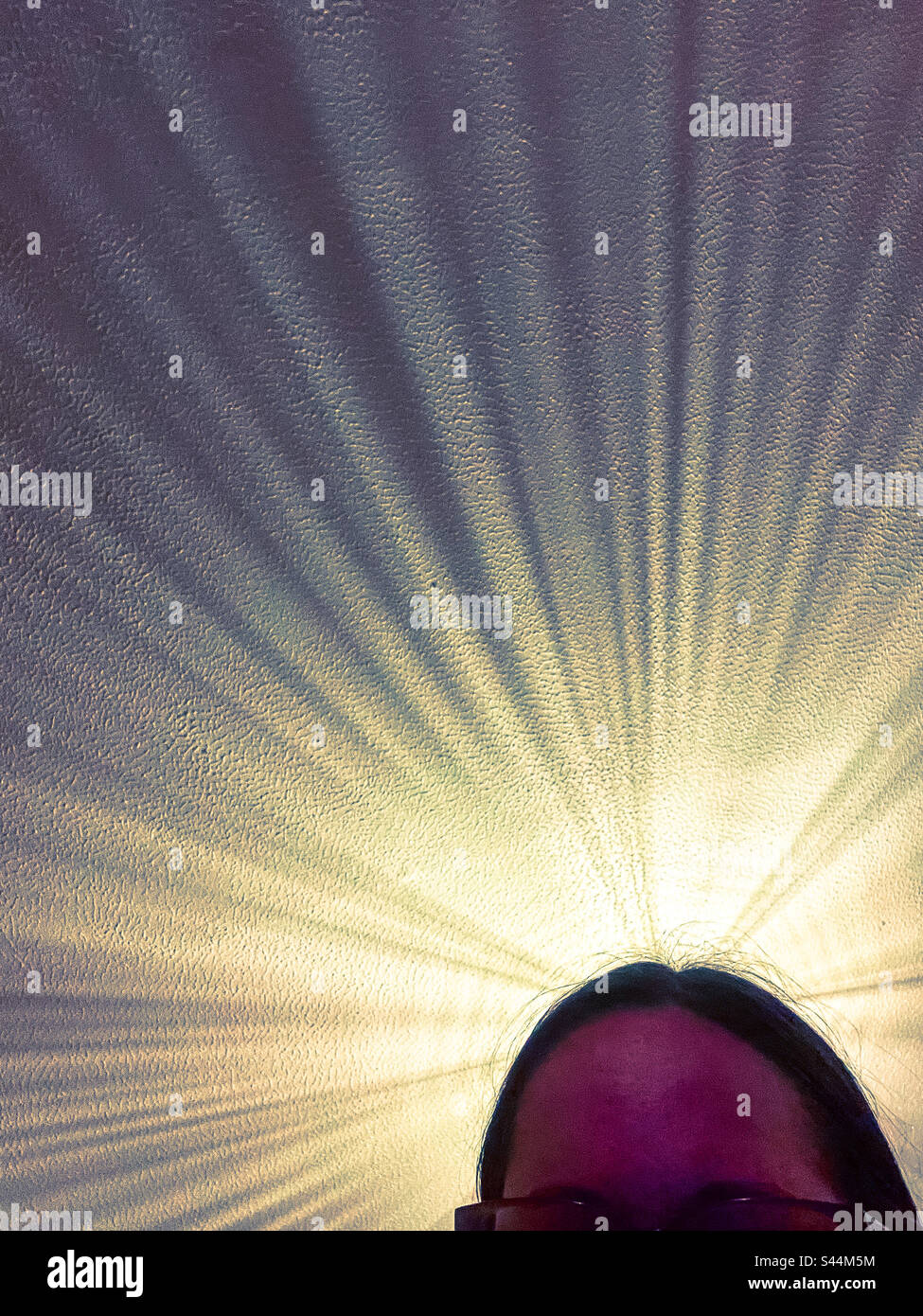 Light shines above woman’s head - Smartphone Captured Stock Image