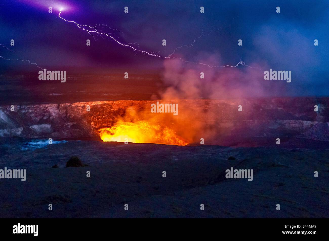 Lightning over a volcano, Hawaii. Force of nature. Primordial. Scene. Dusk. After dark. Halema’uma’u pit Crater. Volcanoes National Park, HI, USA. Stock Photo