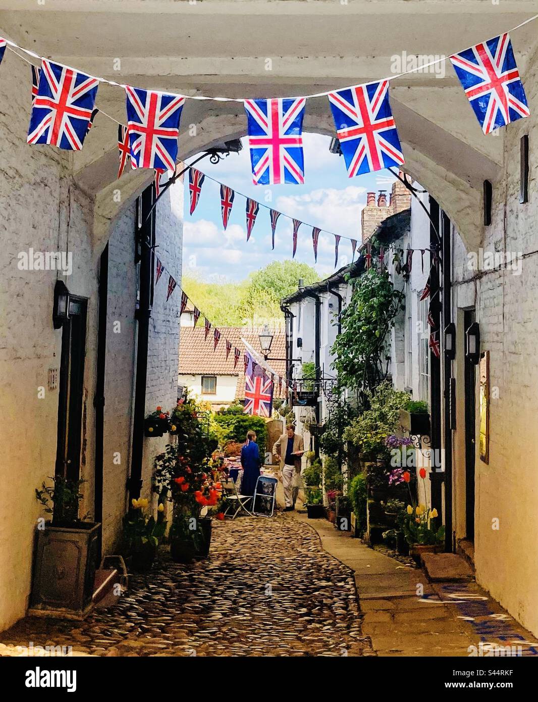 Marble Arch in Knutsford Cheshire off King Street decorated with bunting for coronation day with tables set up for lunch at the end Stock Photo