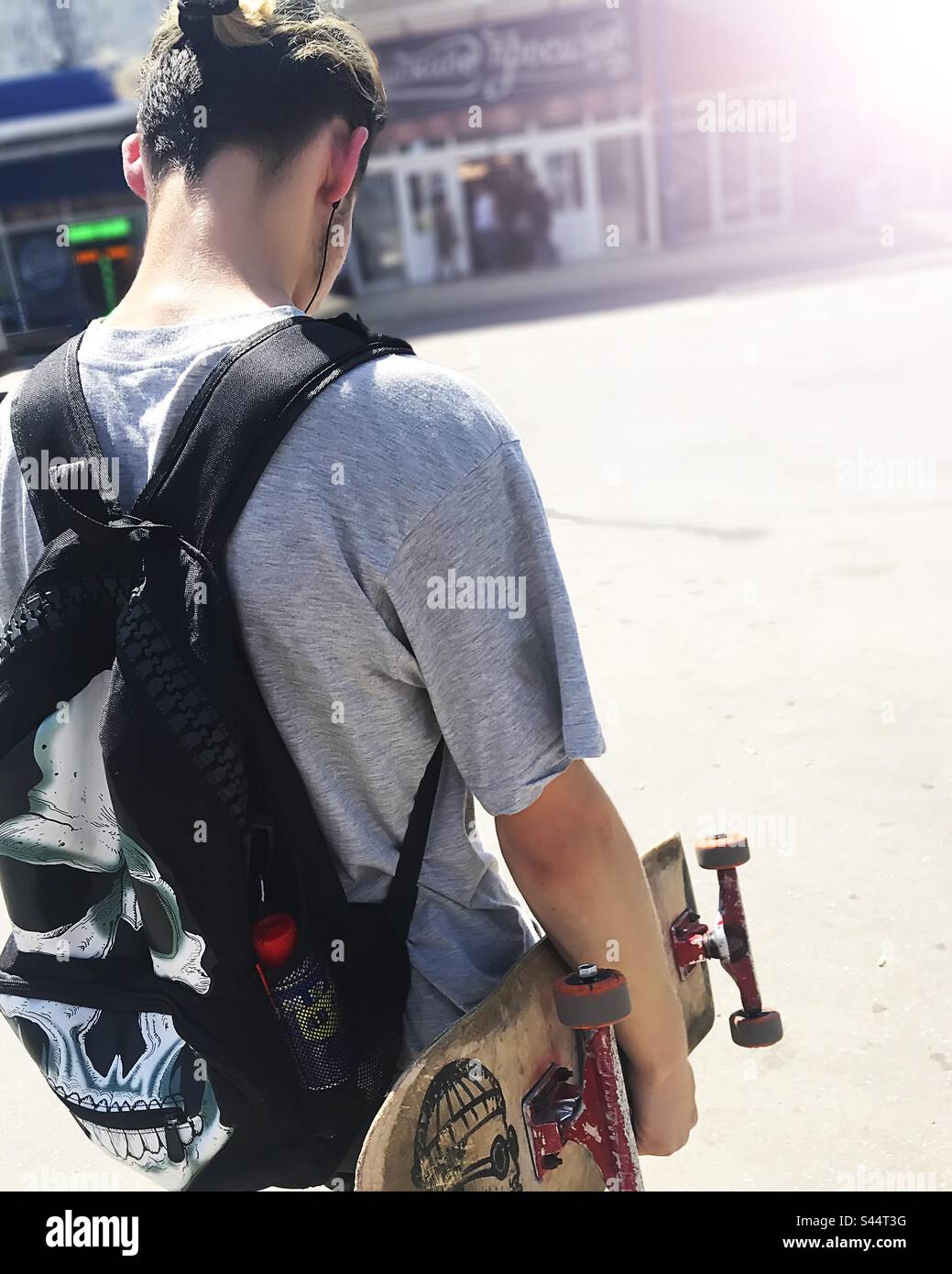 Young man with a skateboarding and backpack - Smartphone Captured Stock Image