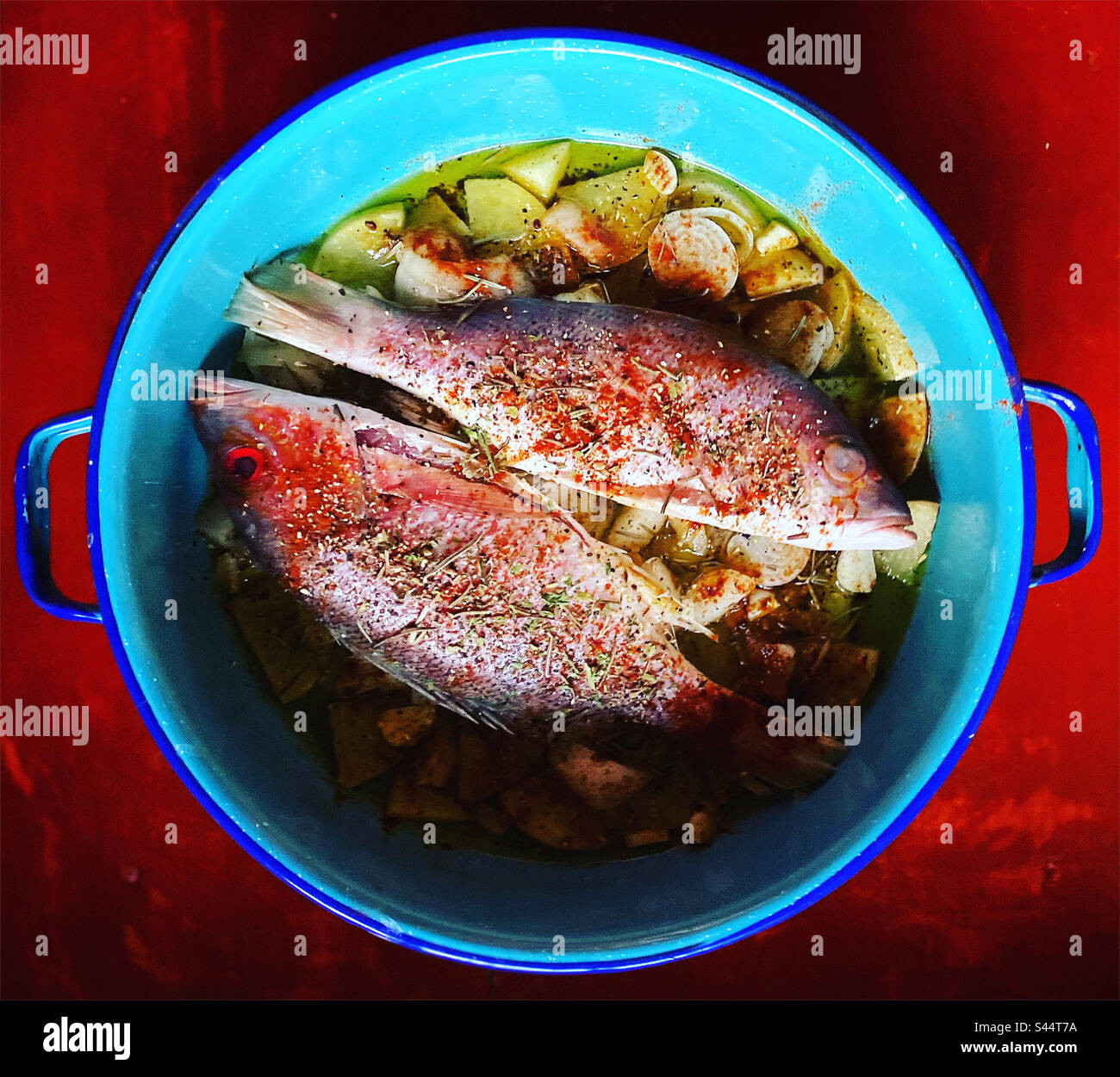 Red snapper fishes with potatoes ready to be cooked in Mexico - Smartphone Captured Stock Image