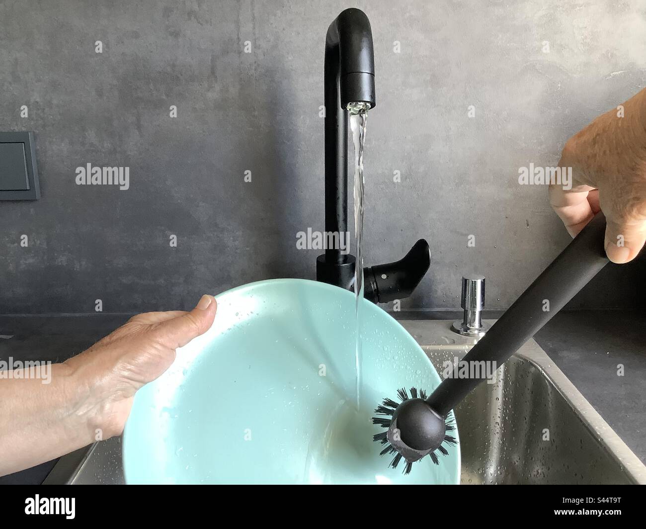 Running water from the tap in the kitchen to wash the dishes with a