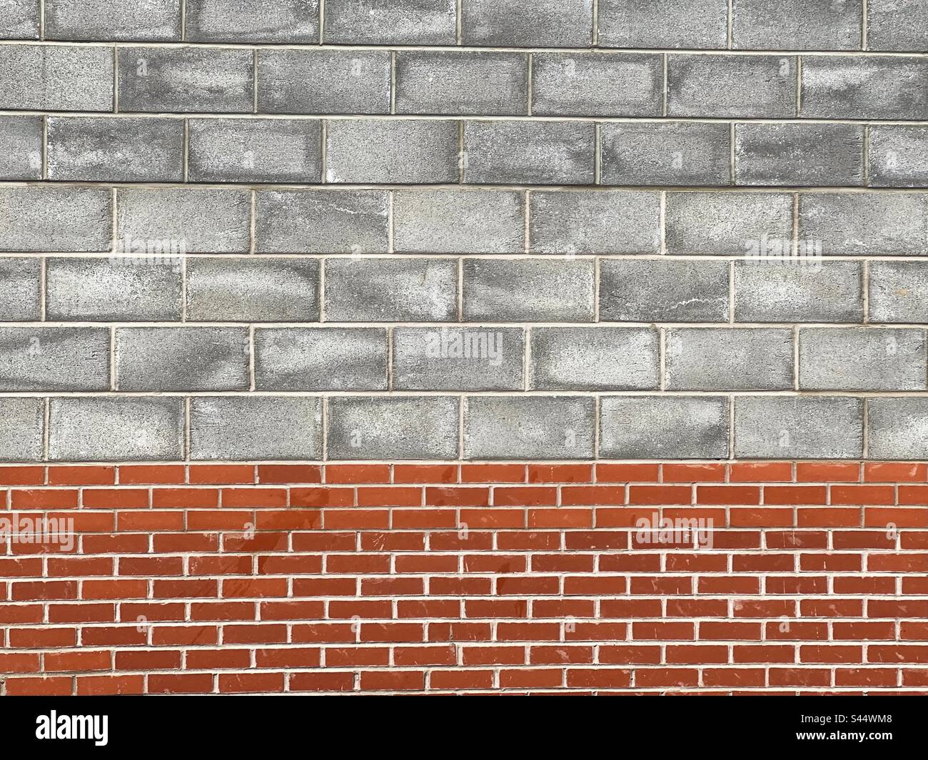 Pattern formed by concrete blacks and house brick in the wall of a building. Backgrounds. - Smartphone Captured Stock Image