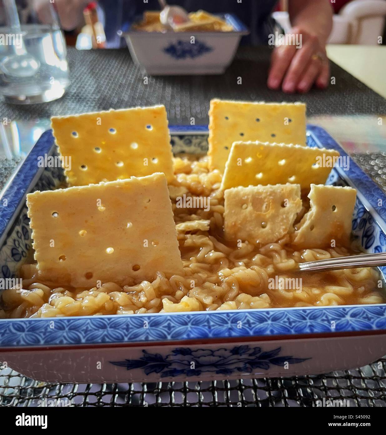 A hot lunchtime treat of Roman noodles with decorative saltine crackers garnish, 2023, USA - Smartphone Captured Stock Image