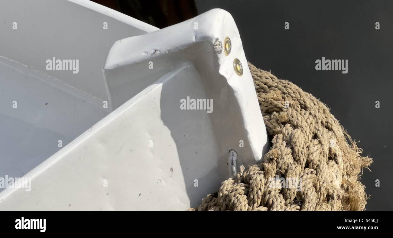 The stem of a small boat moored on the canal in the Netherlands, with a ...