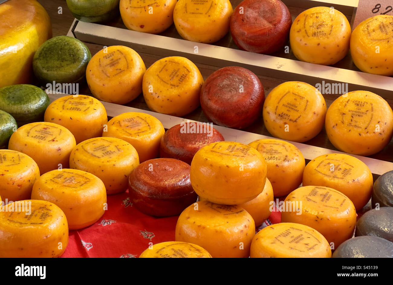 Different coloured miniature Dutch cheeses for sale in a street market in Leiden in the Netherlands - Smartphone Captured Stock Image