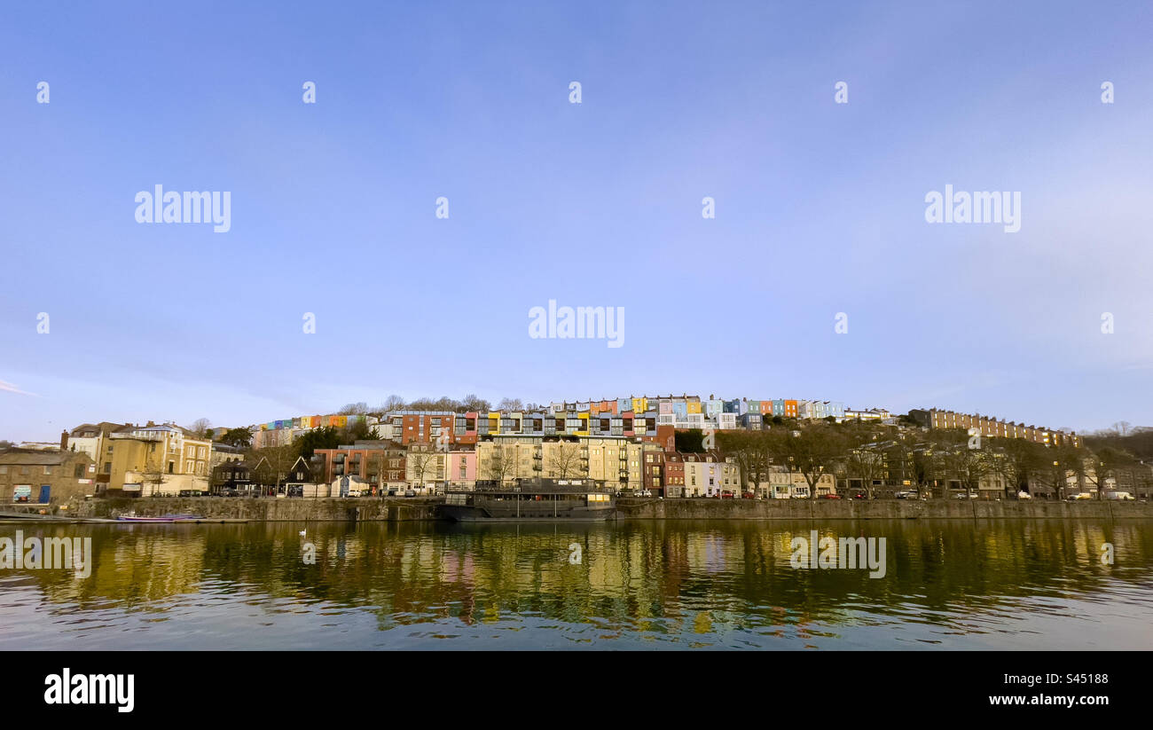 Panoramic view of the Grain Barge floating bar and restaurant with rows of colourful houses behind at sunrise. Bristol Marina. UK - Smartphone Captured Stock Image