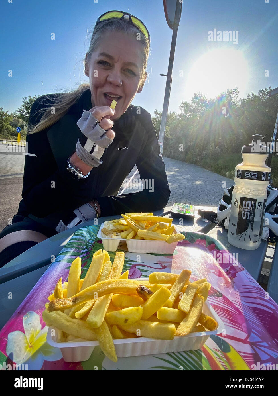 A woman enjoys a snack of chips in the Netherlands - Smartphone Captured Stock Image