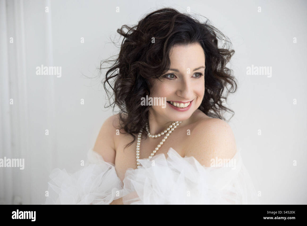 A brunette woman with wavy hair smiling. - Smartphone Captured Stock Image