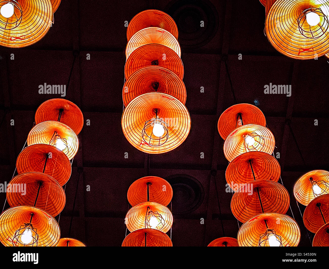 Low angle view of rows of straw hat pendant lights hanging from ceiling. - Smartphone Captured Stock Image