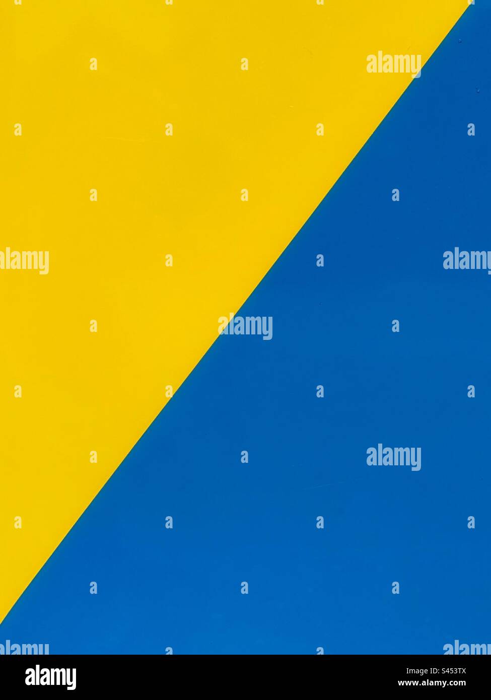 Shiny metal panel painted in yellow and blue triangles. Backgrounds. No people. Stock Photo