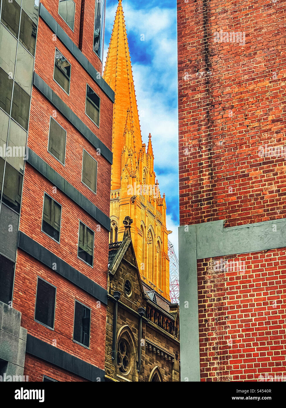 St. Paul’s Cathedral, Melbourne, Australia juxtaposed between two modern buildings in the city. - Smartphone Captured Stock Image