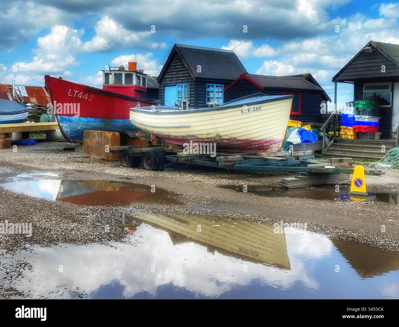 Boats reflected in standing water. Southwold harbour, Suffolk, UK. Stock Photo