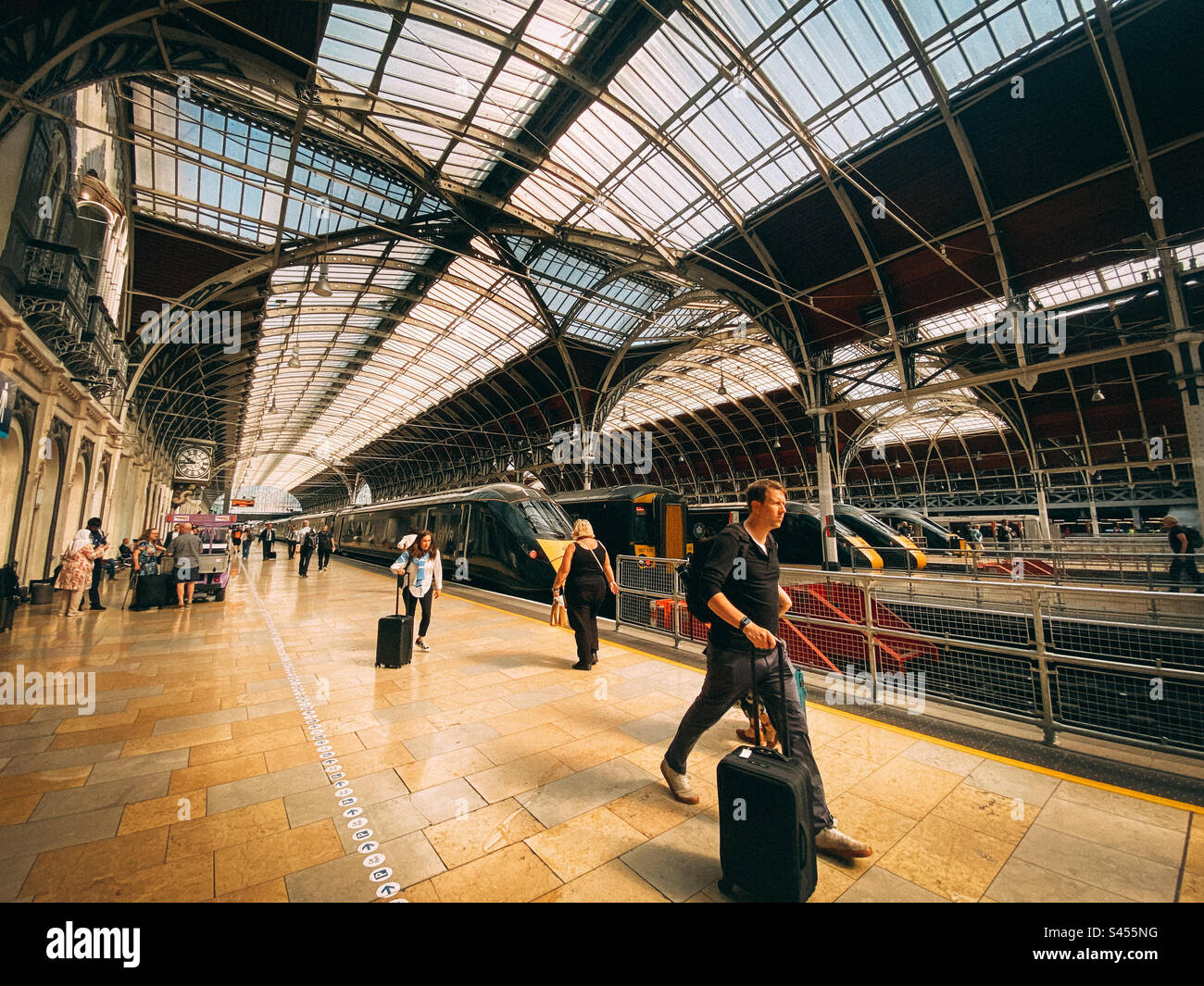 Passengers walk along the platform at Paddington Railway Station in London having disembarked from a train. - Smartphone Captured Stock Image
