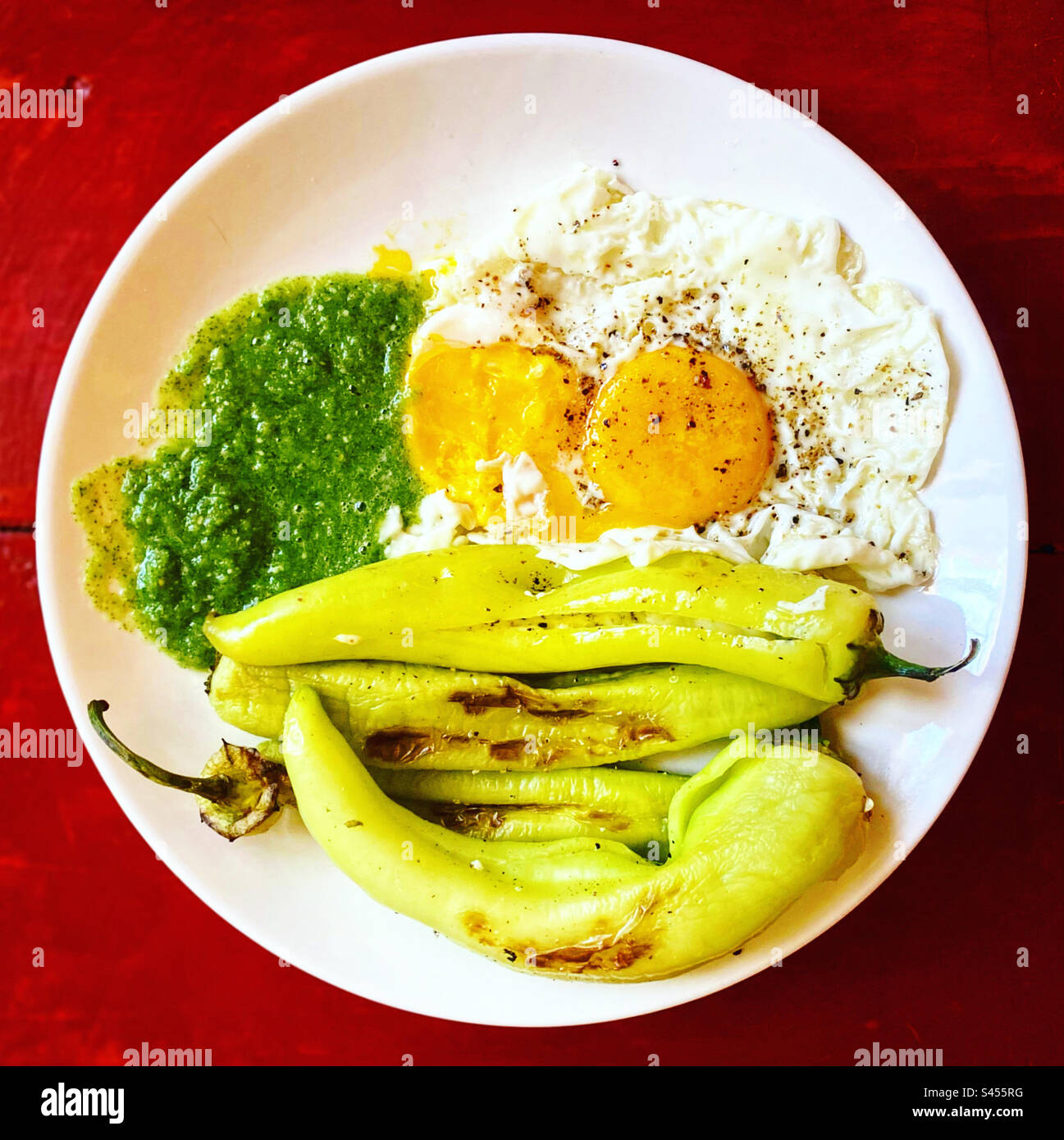 Yellow sweet spicy peppers, with cheese two fried eggs and green tomato sauce for breakfast in Queretaro, Mexico Stock Photo