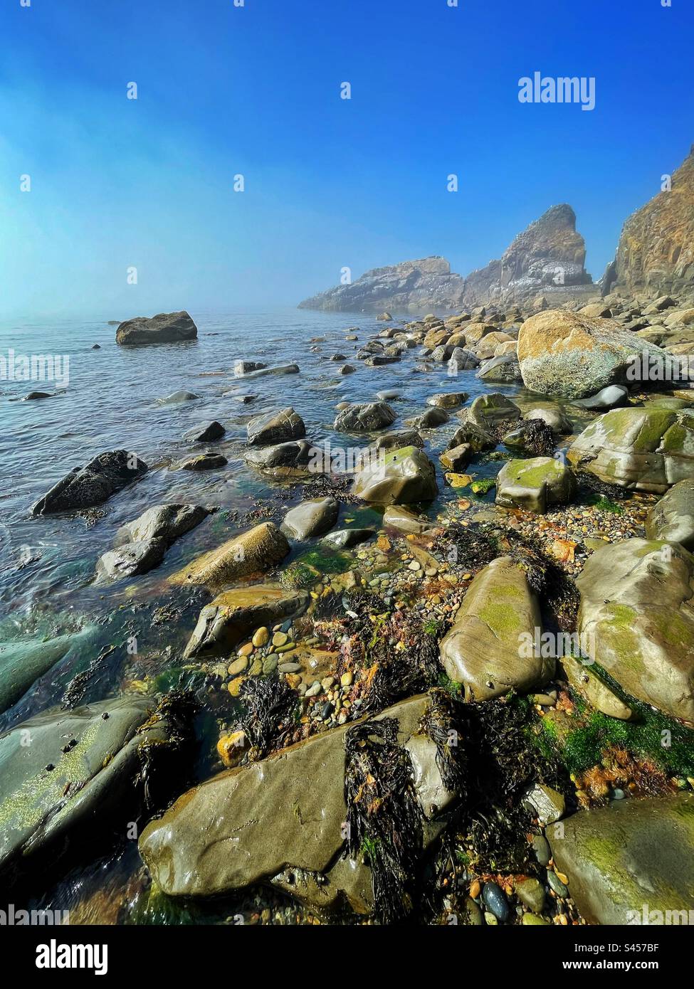 Pistyll beach, Lleyn Peninsula, Gwynedd, North Wales, June, with clearing sea mist and clear blue sky. - Smartphone Captured Stock Image