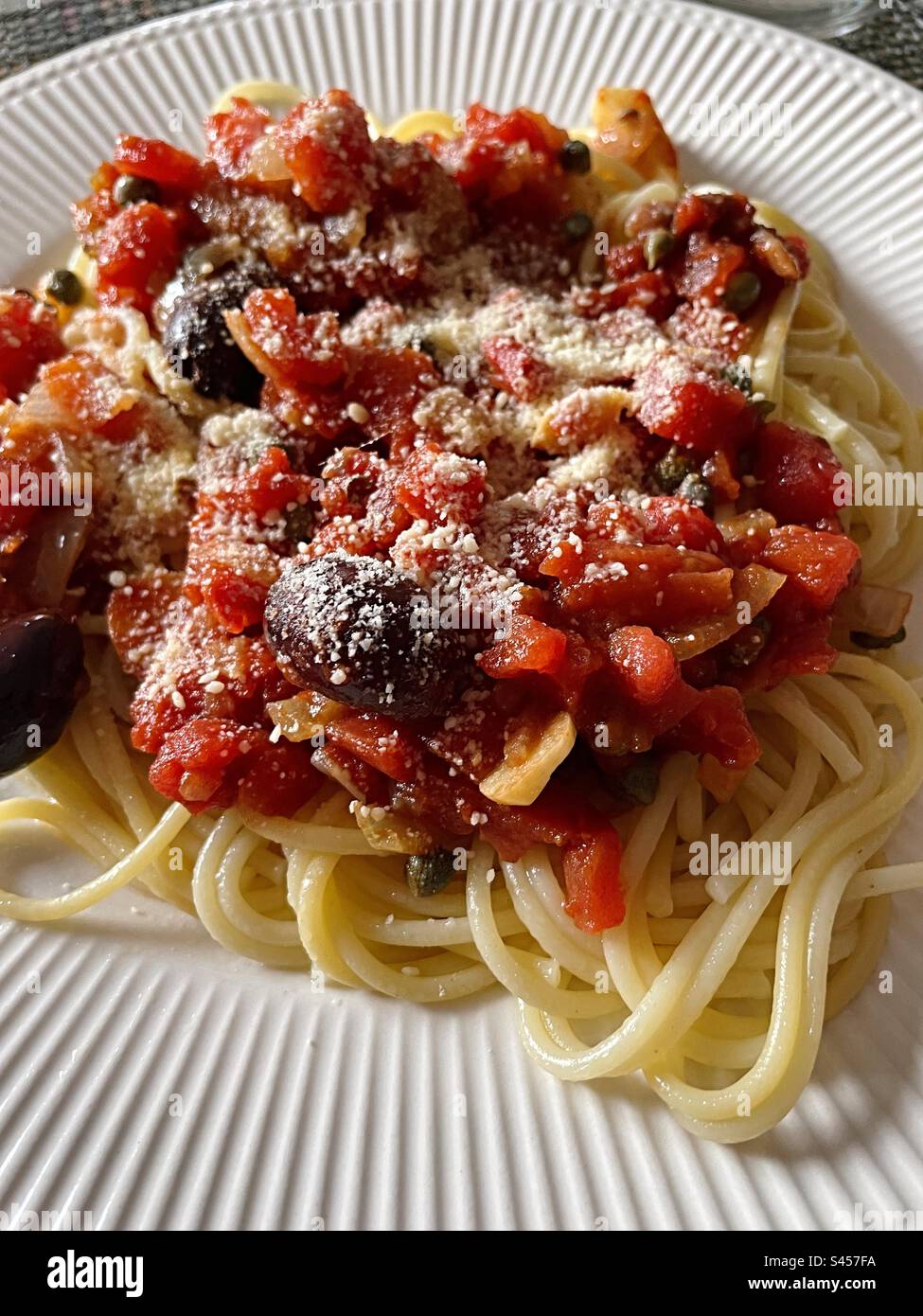 Close up of a main course Italian pasta meal of puttanesca on spaghetti noodles, 2023, USA - Smartphone Captured Stock Image