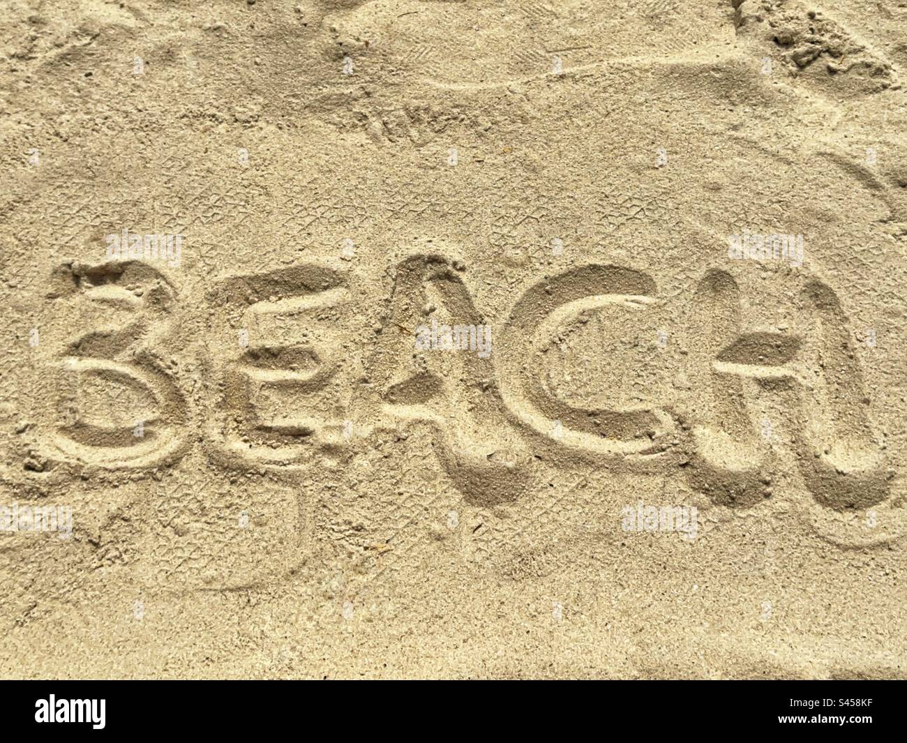The word “Beach” written in fine sand on a tropical beach. Stock Photo