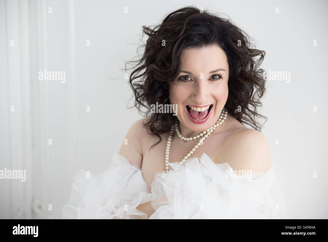 A 40 year old brunette woman laughing. - Smartphone Captured Stock Image