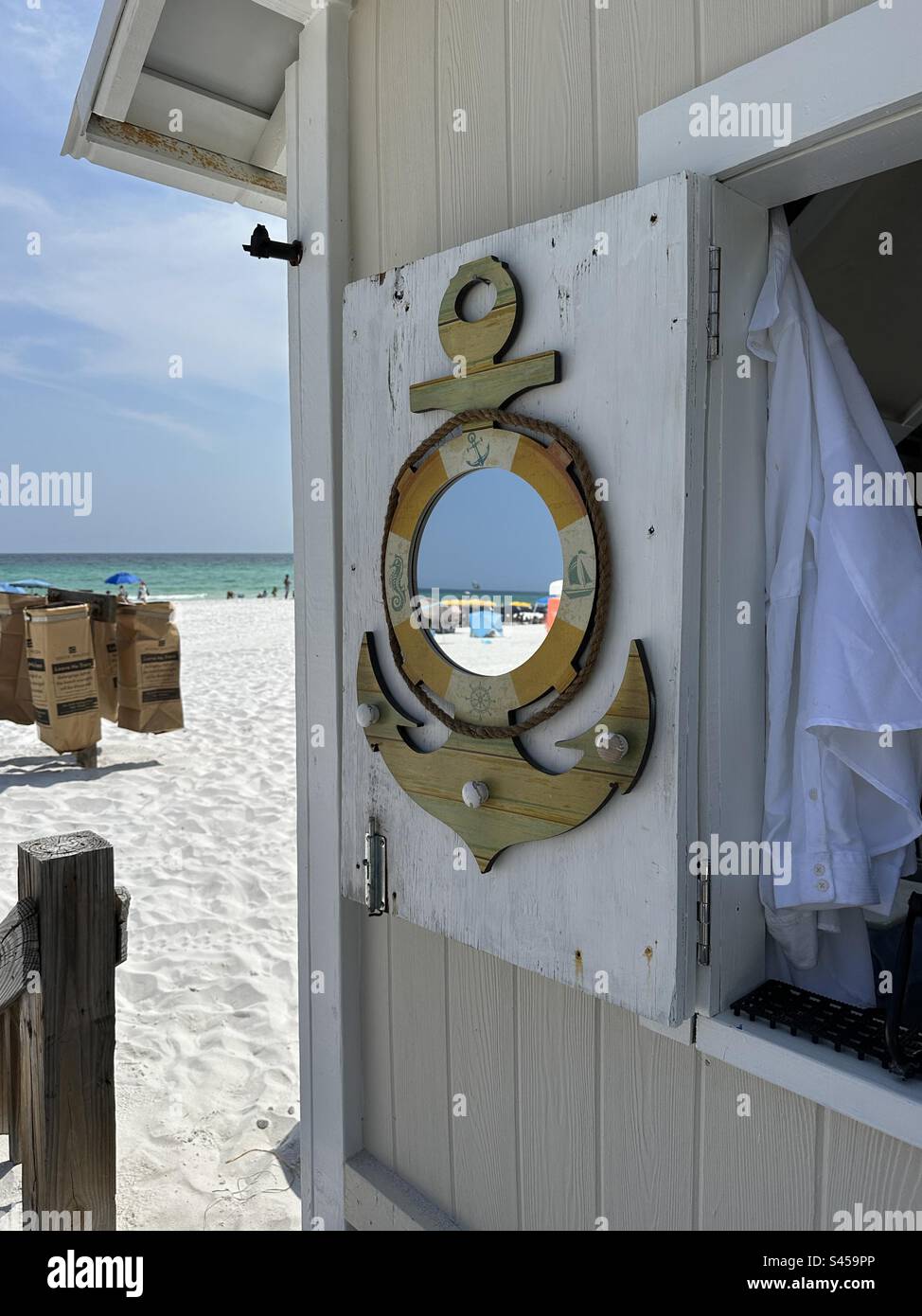Nautical outdoor mirror decoration on beach hut with reflections in mirror - Smartphone Captured Stock Image