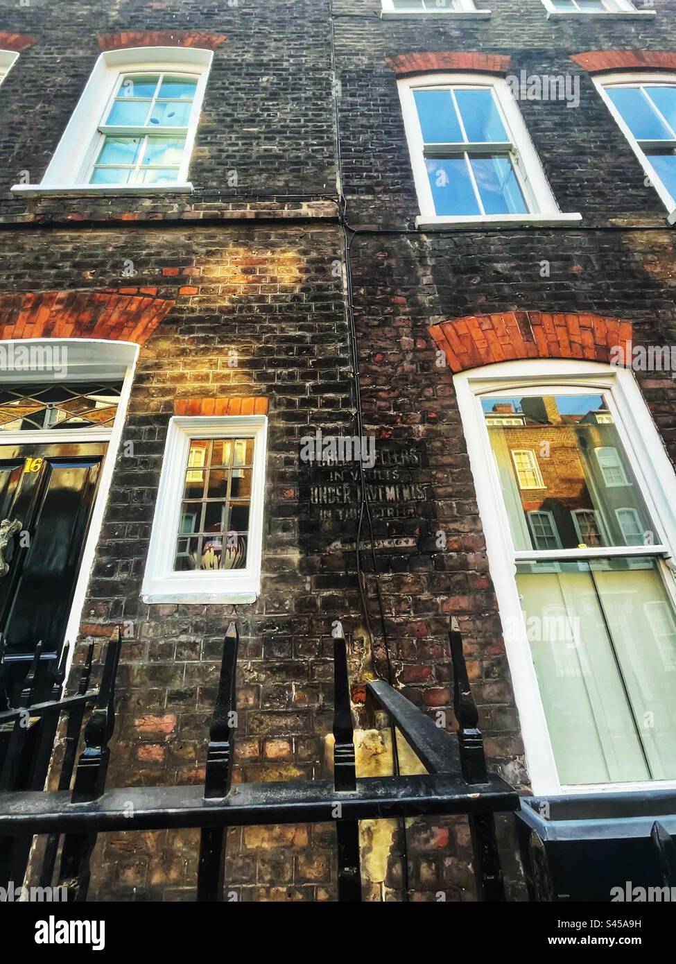 Ghost sign in Lord North Street in Westminster, London SW1 reads: “Public shelters in vaults under pavements in this street.” Second World War directions for public safety from bombs - Smartphone Captured Stock Image