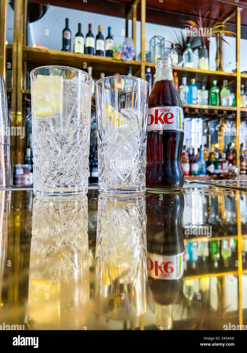Glass of lemonade and Diet Coke on bar in trendy bar Stock Photo