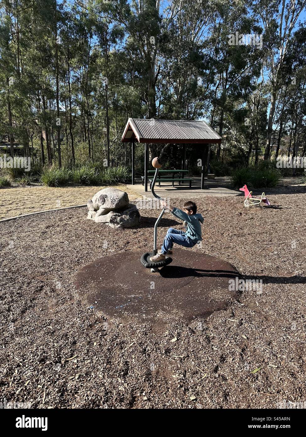 Boy spins on playground Stock Photo