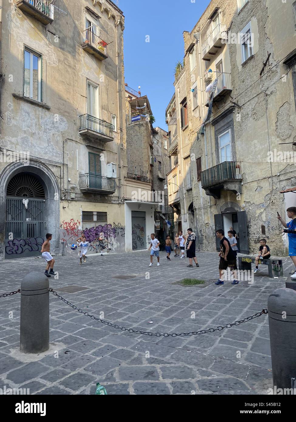 Kids playing football in a Naples alley Stock Photo