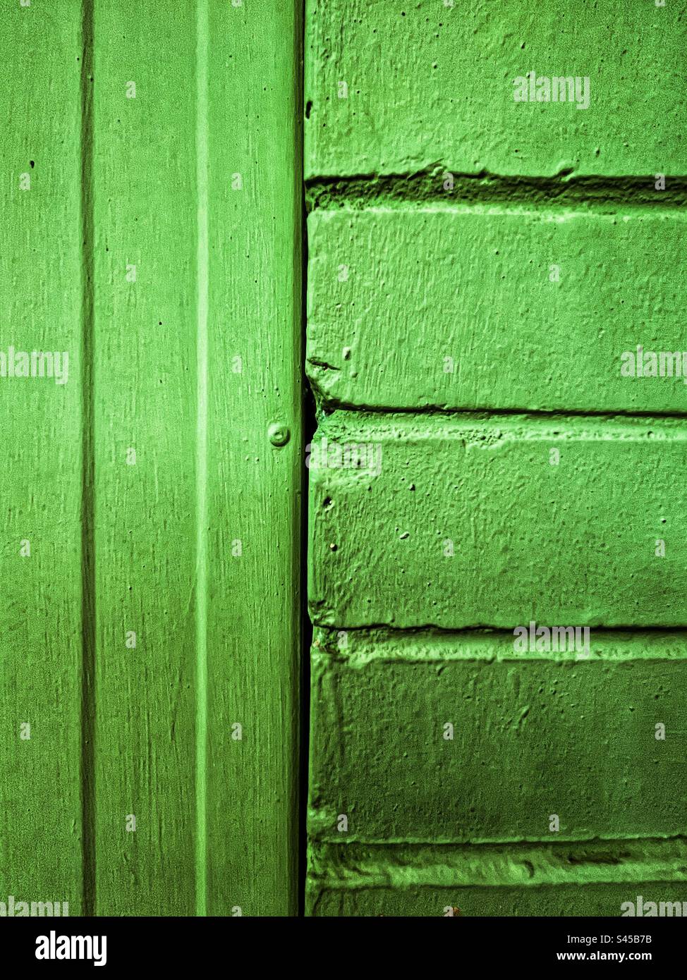 Close-up of green brick wall next to green wooden fence. Full frame backgrounds. Pattern. Lines. Texture. - Smartphone Captured Stock Image