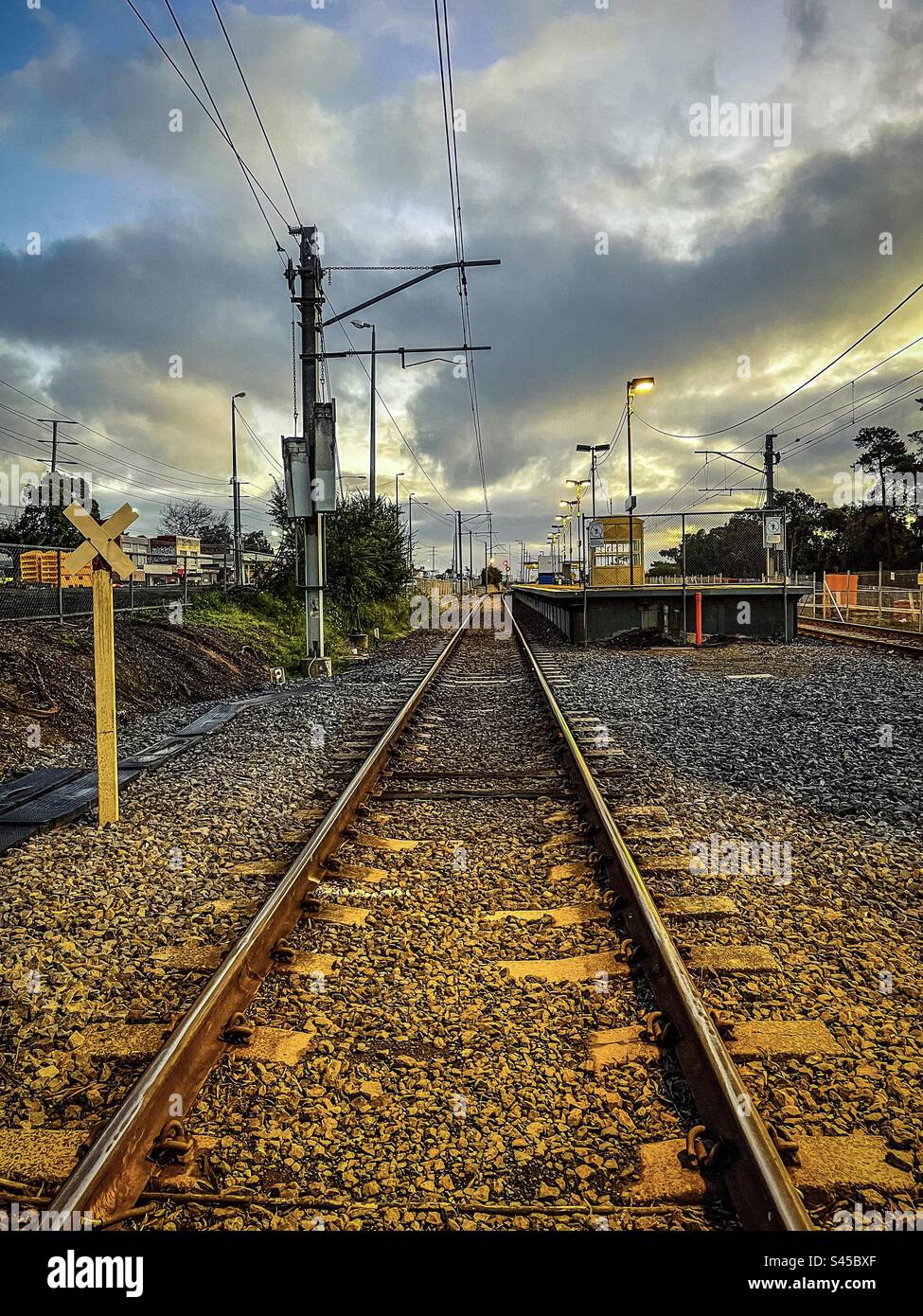 Railroad track, railway station and power line against cloudy sunset sky. Public transportation. - Smartphone Captured Stock Image