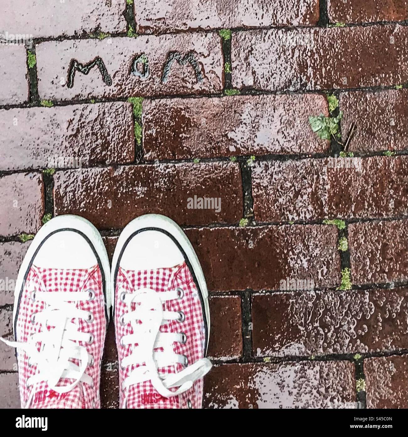 Red and White Converse Shoes on Wet Tiled Floor with MOM Text - Smartphone Captured Stock Image