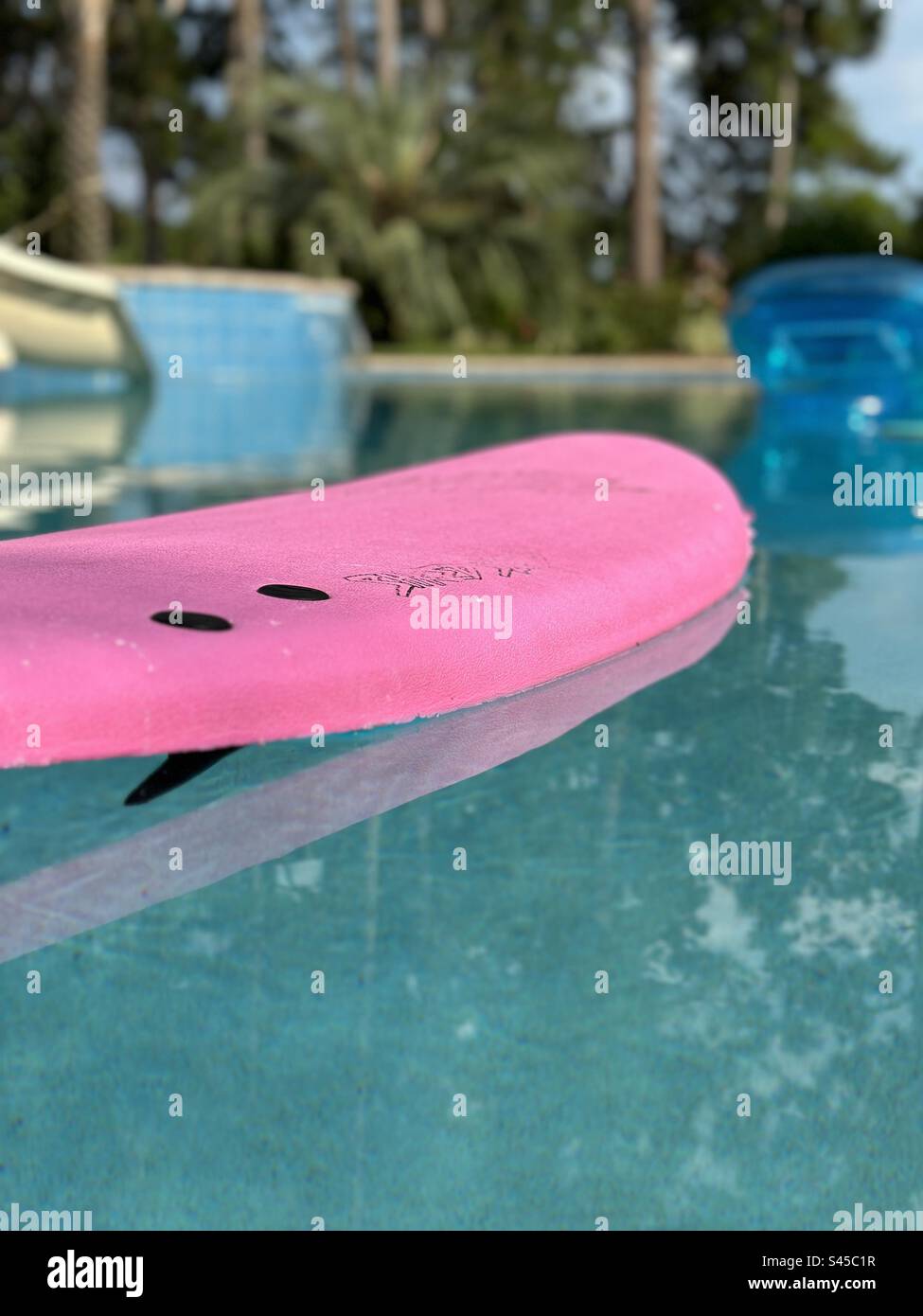 Pink skim board with reflections in a swimming pool - Smartphone Captured Stock Image