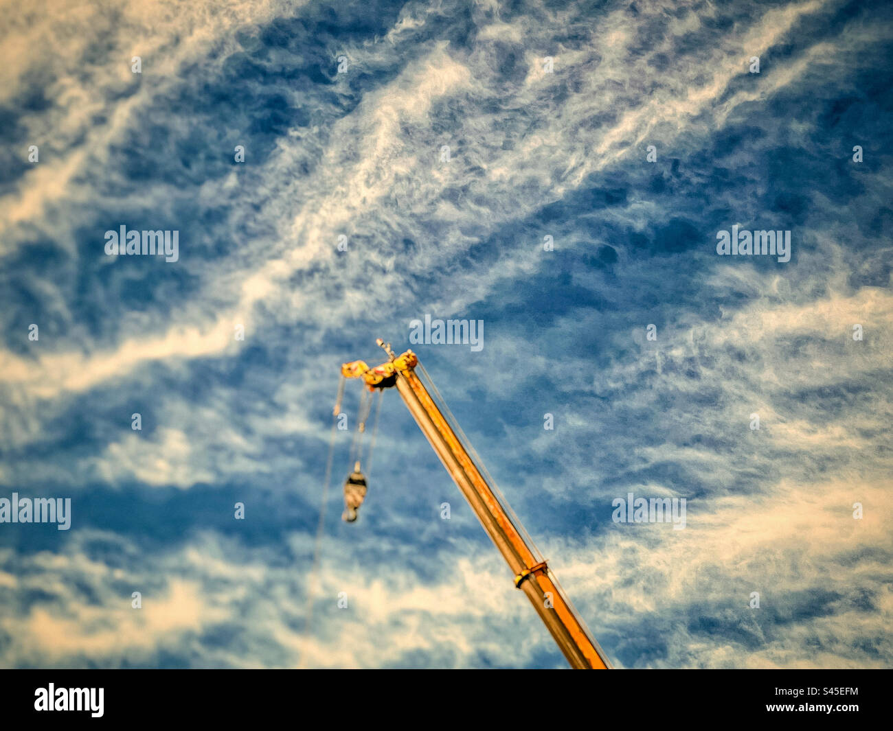 Low angle view of construction crane against blue sky with clouds. Stock Photo