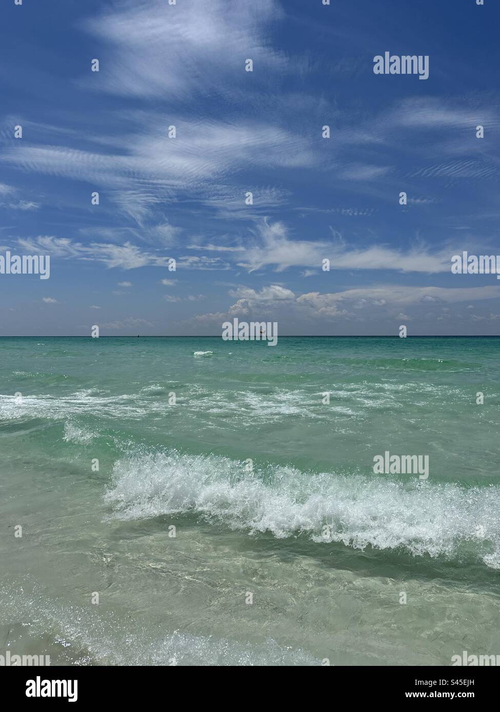 Crashing waves over the Gulf of Mexico Florida Emerald Coast with distant parasail - Smartphone Captured Stock Image